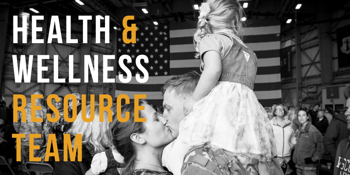 Soldier Returning from Deployment kissing his wife and holding his child.